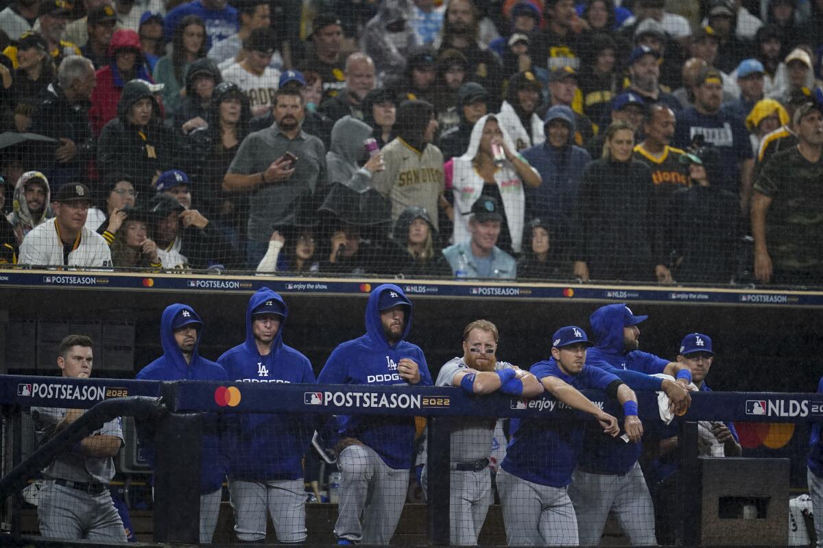 Members of the Los Angeles Dodgers look on from the dugout during the ninth inning in Game 4 of a baseball NL Division Series against the San Diego Padres, Saturday, Oct. 15, 2022, in San Diego. (AP Photo/Ashley Landis)