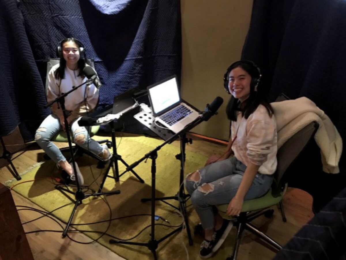 Twin sisters Emily and Evelyn Tran of Fountain Valley are pictured podcasting together.