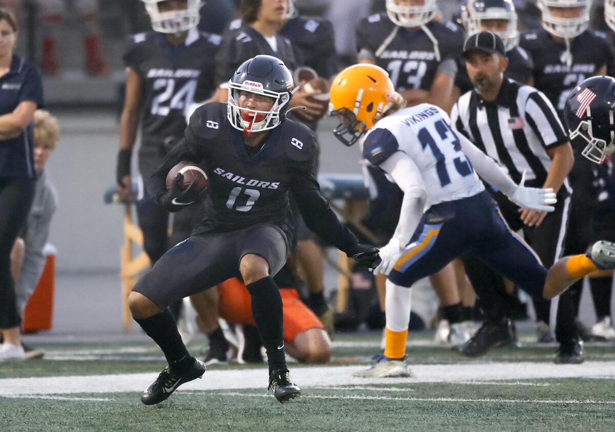 Newport Harbor's Josiah Lamarque (8) makes a move as he runs into the end zone for a touchdown against Marina on Aug. 26.