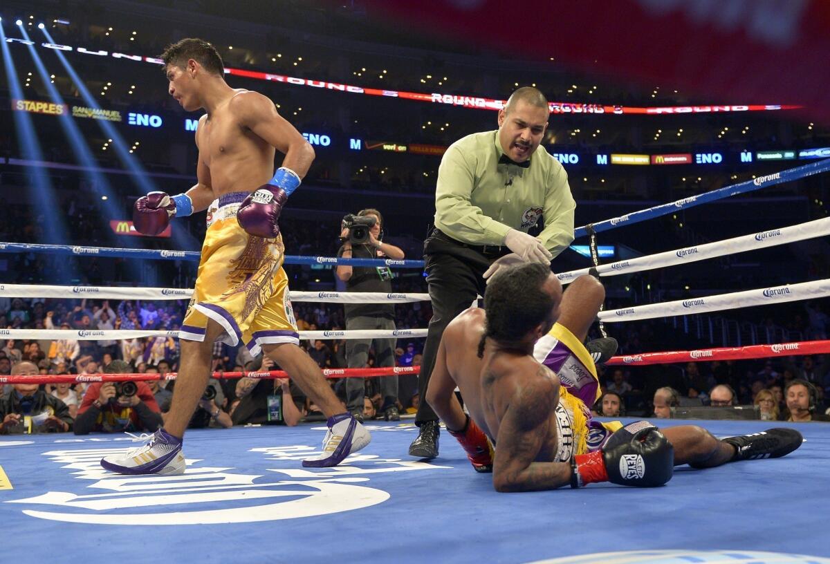 Abner Mares, left, walks away after becoming the first person to knock down Anselmo Moreno, during the fifth round of their WBC super-bantamweight title bout Saturday at Staples Center.