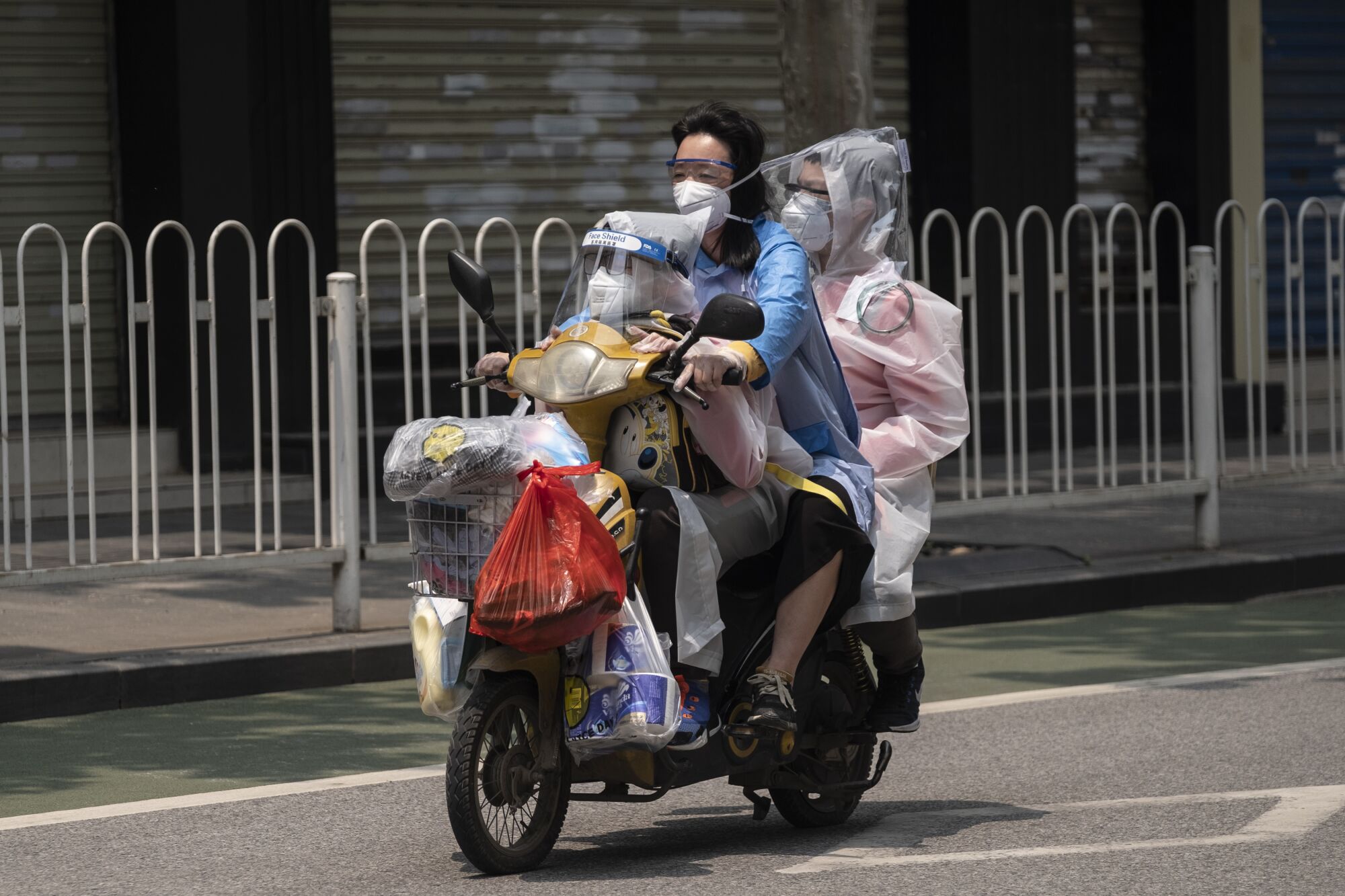 Wuhan's lockdown has lifted, but anxieties about the coronavirus remain. Travelers, above, take precautions while heading to the grocery store.