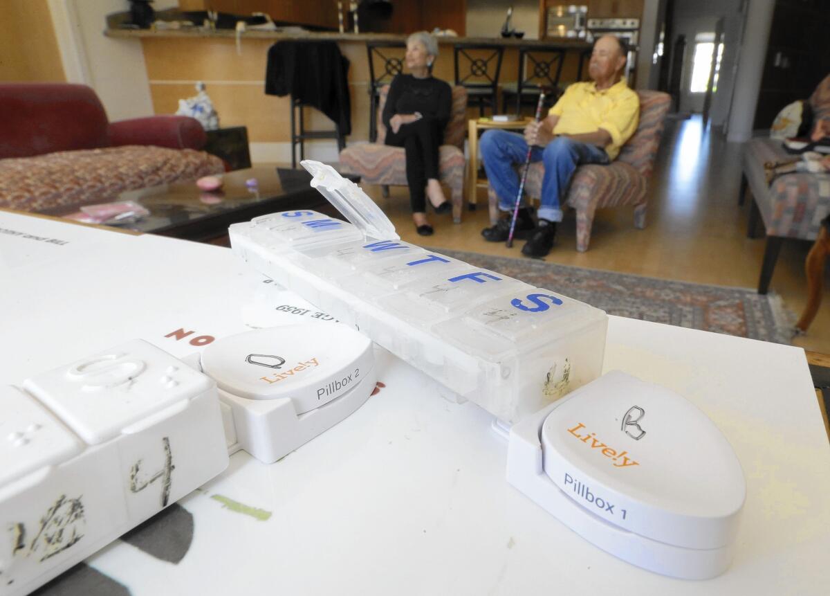 Sensors are attached to pill containers at the home of Dorothy, 80, rear left, and Bill Dworsky, 81, in San Francisco. Their son is alerted when the containers are opened.