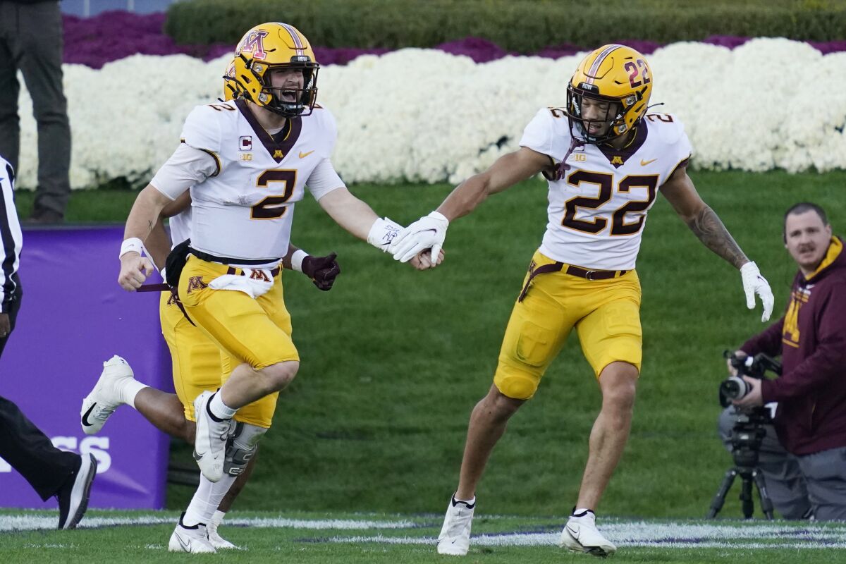 Minnesota quarterback Tanner Morgan, left, celebrates with wide receiver Mike Brown-Stephens after scoring a touchdown during the second half of an NCAA college football game against Northwestern in Evanston, Ill., Saturday, Oct. 30, 2021. (AP Photo/Nam Y. Huh)