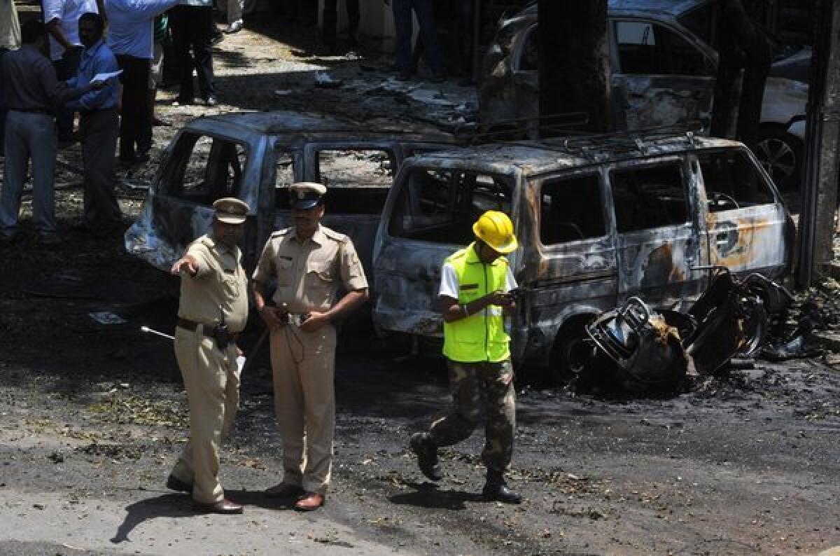 Police and forensic experts inspect the site of a bomb blast near a Bharatiya Janata Party office in Bangalore, India.