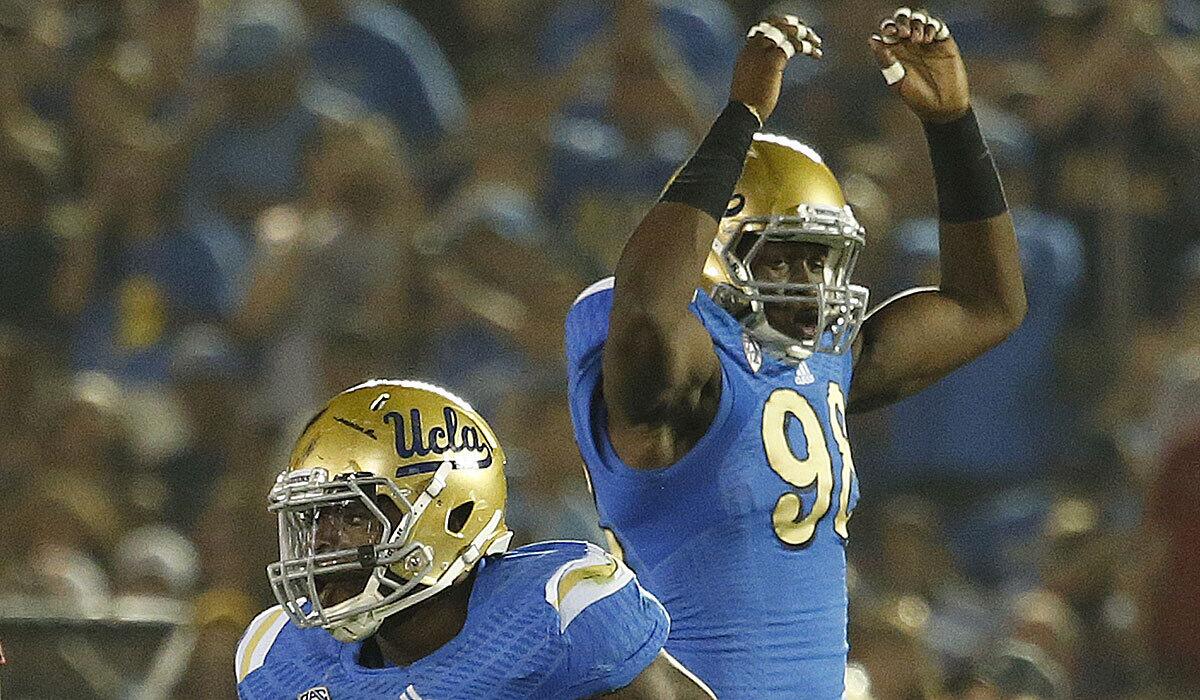 Bruins defensive linemen Takkarist McKinley, right, and Owamagbe Odighizuwa react after a defensive stop against Utah at the Rose Bowl on Oct. 4.