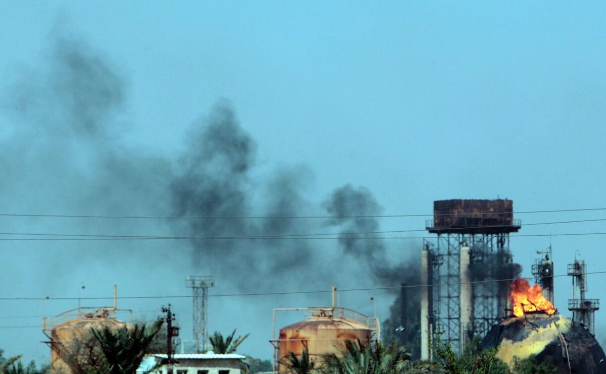 Flames and smoke rise from tanks after a militant attack on the Taji natural gas plant.