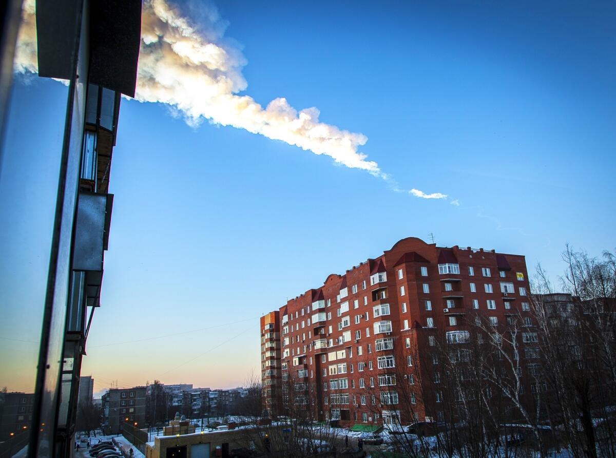 A meteorite trail seen above a residential apartment block in the Urals city of Chelyabinsk, Russia.