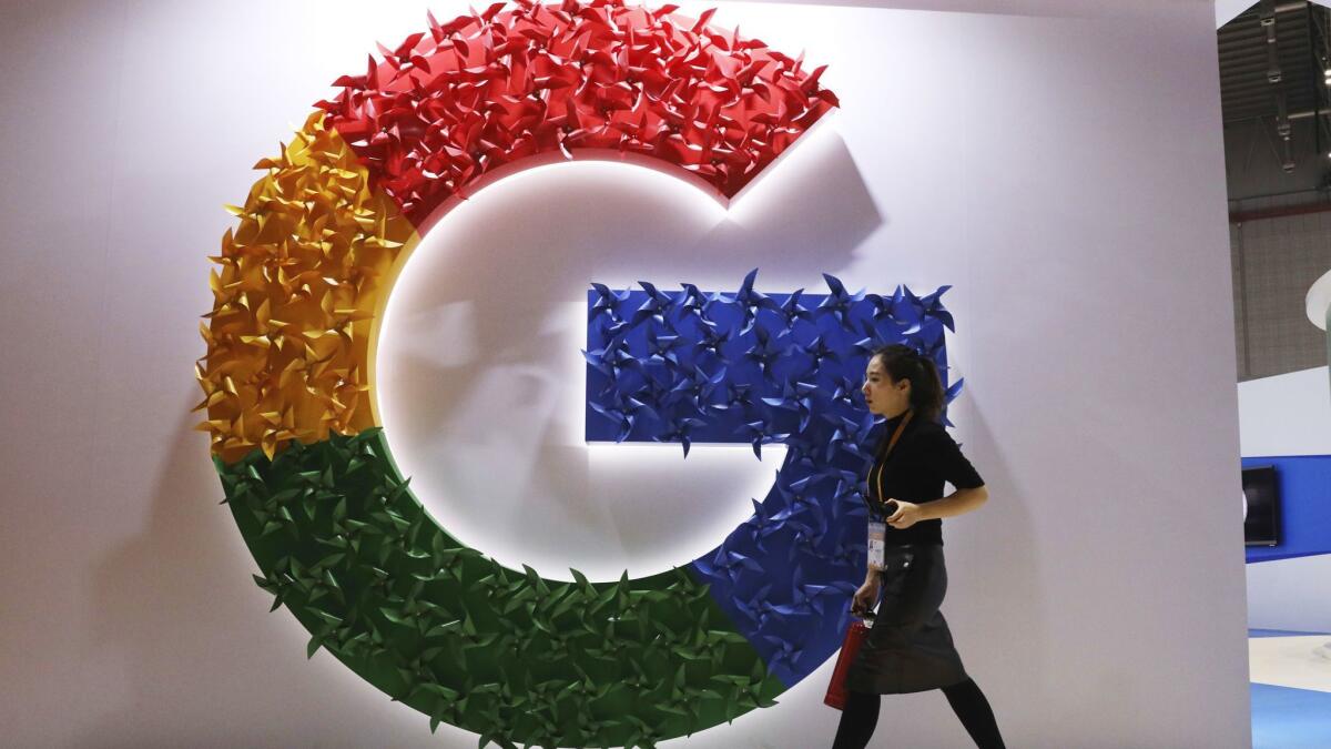 A woman walks past the Google logo at an expo in November.