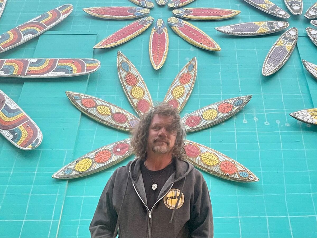 Artist Rob Tobin with part of the mosaic mural he has designed.