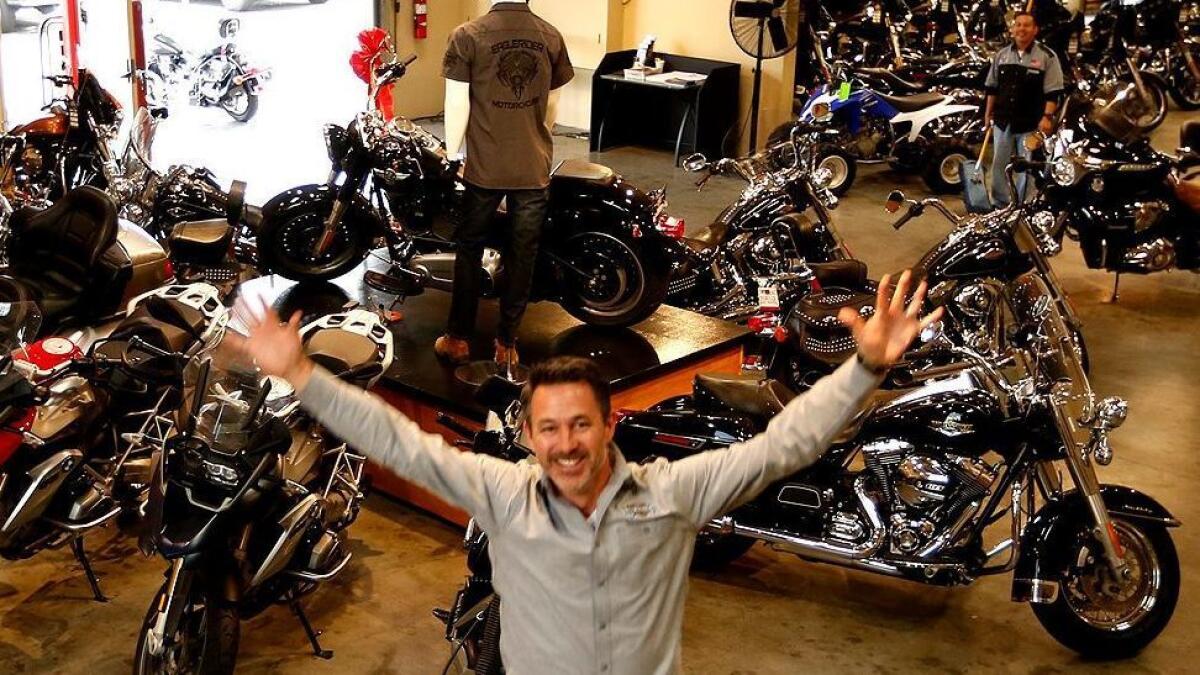 Chris McIntyre, CEO and co-founder of the motorcycle tourism company EagleRider, jumps for joy at his Hawthorne headquarters.