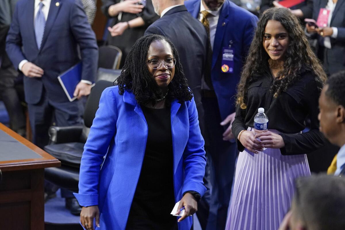 Judge Ketanji Brown Jackson and observers standing at her Supreme Court confirmation hearing.