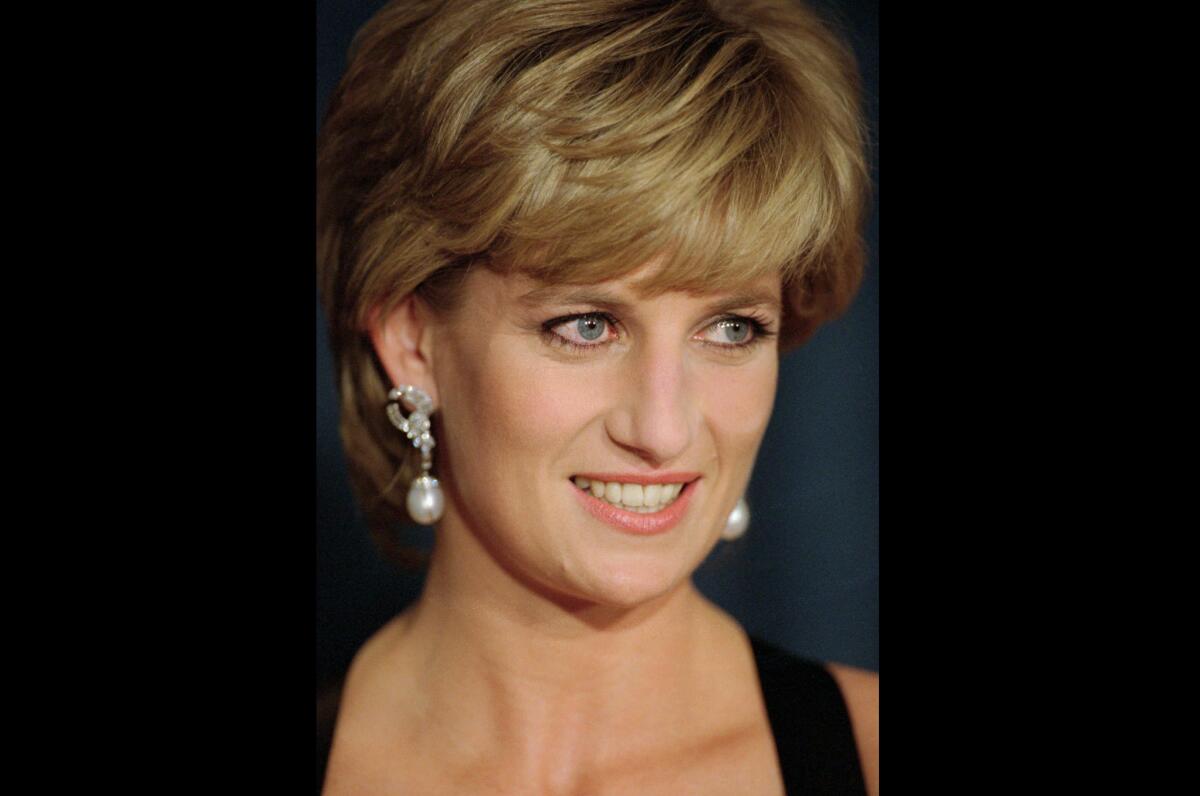 A closeup of Princess Diana in black dress and elaborate earrings.