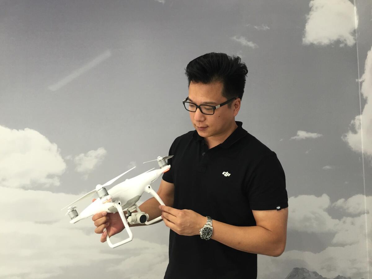 Paul Pan, a senior product manager at DJI, examines a Phantom 4 drone at the company's headquarters in Shenzhen, China.