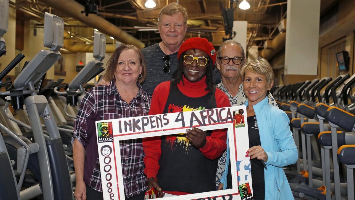 Kiro, center, poses with his gym friends and donors, Vikki LePou, bottom right, a 24 Hour Fitness personal trainer, Jerry King, top right, John Waters and his wife Susie pose for a portrait at 24 Hour Fitness in Costa Mesa.
