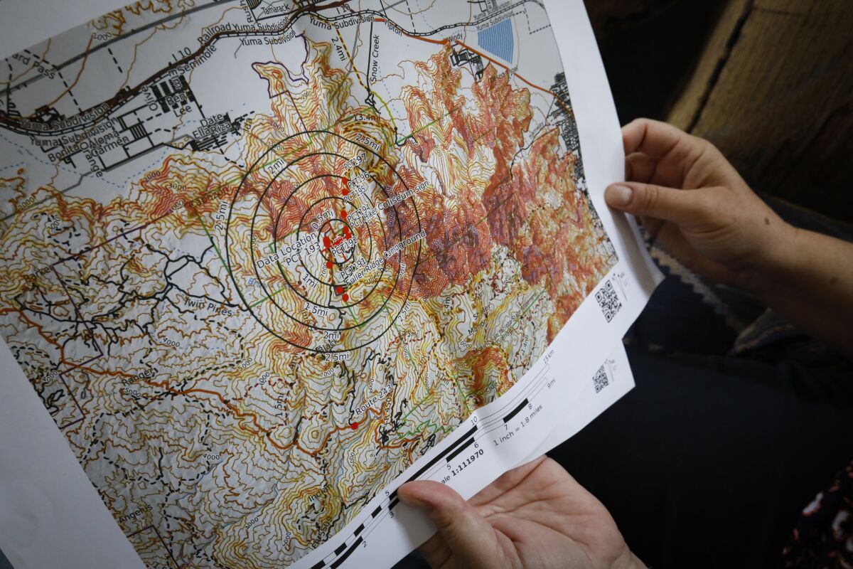 Theresa Sturkie  holds a map at her home on May 21, 2019 in Oceanside, California, with circles indicating a two-and-a-half-mile radius around the location in the Mount San Jacinto State Park and Wilderness Area in Riverside County where her husband, John Sturkie's truck was found three months after he was last seen on January 5.
