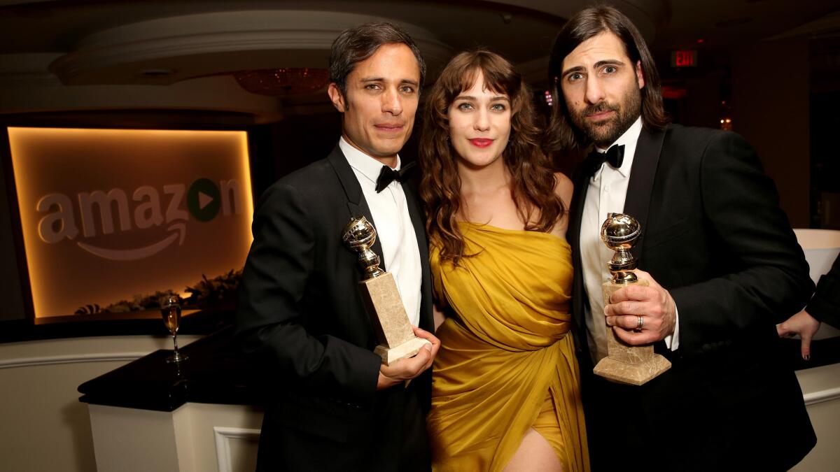 "Mozart in the Jungle" actors Gael Garcia Bernal, left, and Lola Kirke celebrate with actor, writer and show co-creator Jason Schwartzman at Amazon's Golden Globe Awards celebration.