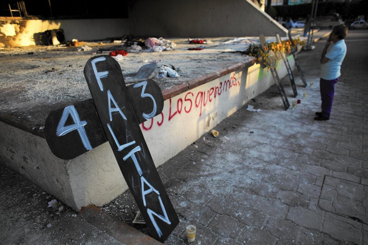 A cross marked with “43 are missing” leans near the Iguala town hall, which was scorched during protests over the disappearance of 43 students, who were rounded up by local police Sept. 26.