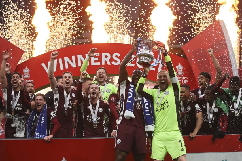 Leicester's goalkeeper Kasper Schmeichel, right, and Leicester's Wes Morgan lift the trophy after winning the FA Cup final soccer match between Chelsea and Leicester City at Wembley Stadium in London, England, Saturday, May 15, 2021. Leicester won 1-0. (Nick Potts/Pool via AP)