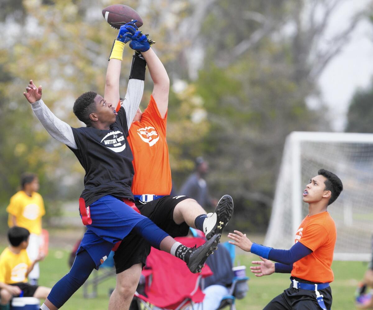 Jeffrey Trail Middle School's Davyon Lesure, left, breaks up a pass intended for South Lake's Dario Amirghari, center, during the Irvine Public Schools Foundation's second annual Winter Bowl flag football tournament at Orange County Great Park in Irvine on Saturday. South Lake's Branton Lucas, right, caught the ball and ran for a touchdown. South Lake won, 25-12.