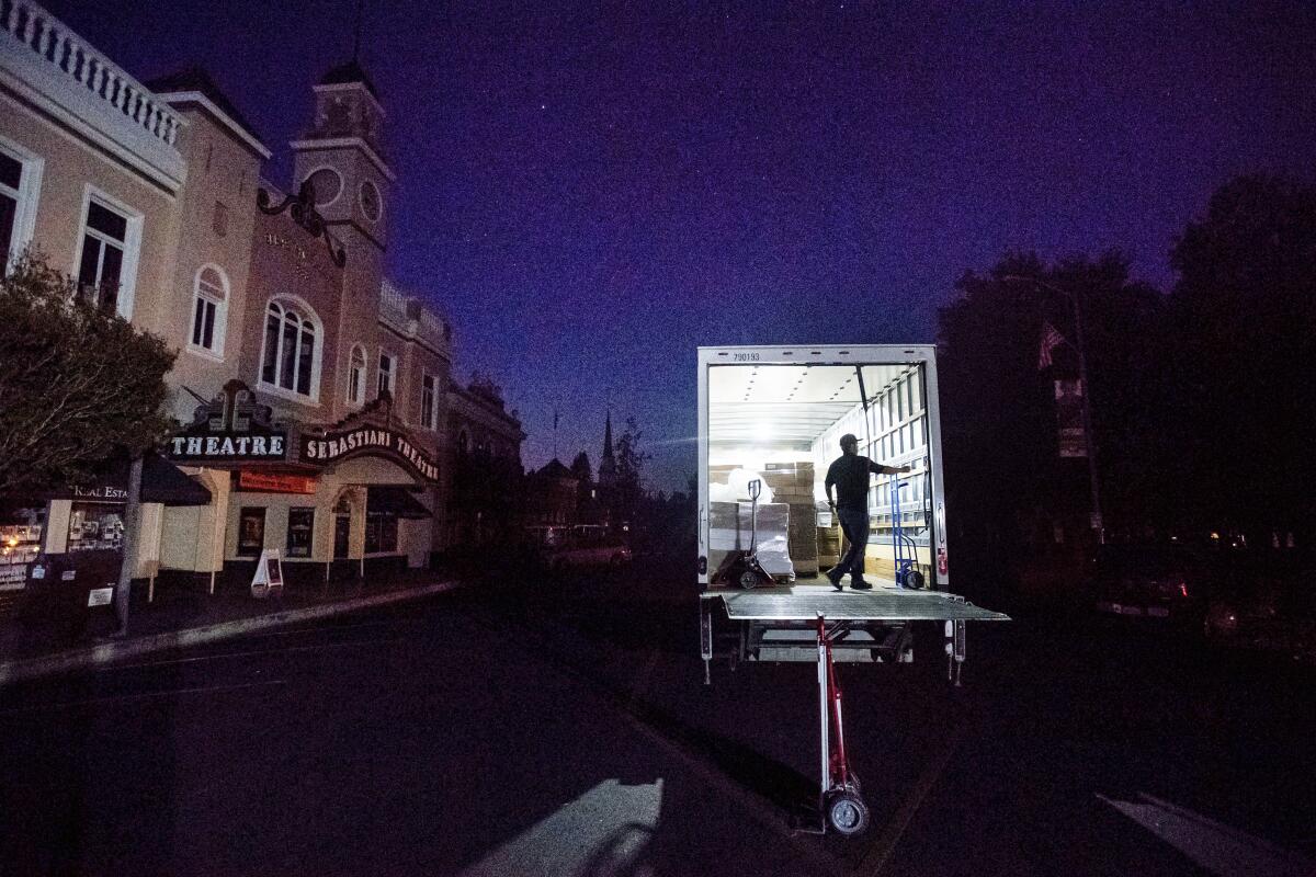 Armando Espinoza delivers paper products to a cafe in downtown Sonoma, where power is turned off