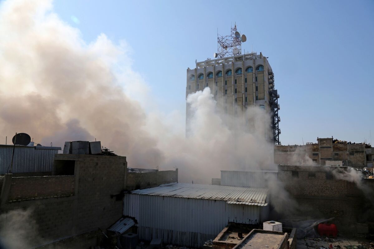 Smoke rises after a parked car bomb went off at a commercial center in central Baghdad.