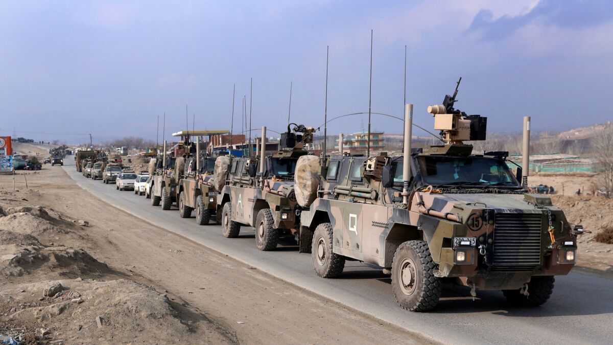 International troops' military tanks leave the scene of a suicide bomb attack that targeted a convoy of security forces on the outskirts of Kabul, Afghanistan on Dec. 11.