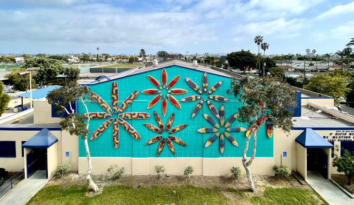 A flower design made out of surf boards decorated with mosaic is being installed on the PB Recreation Center’s north wall.