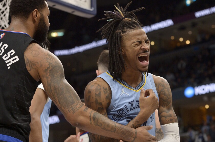 Memphis Grizzlies guard Ja Morant (12) reacts after being fouled by Los Angeles Clippers forward Marcus Morris Sr., left, in the second half of an NBA basketball game Tuesday, Feb. 8, 2022, in Memphis, Tenn. (AP Photo/Brandon Dill)