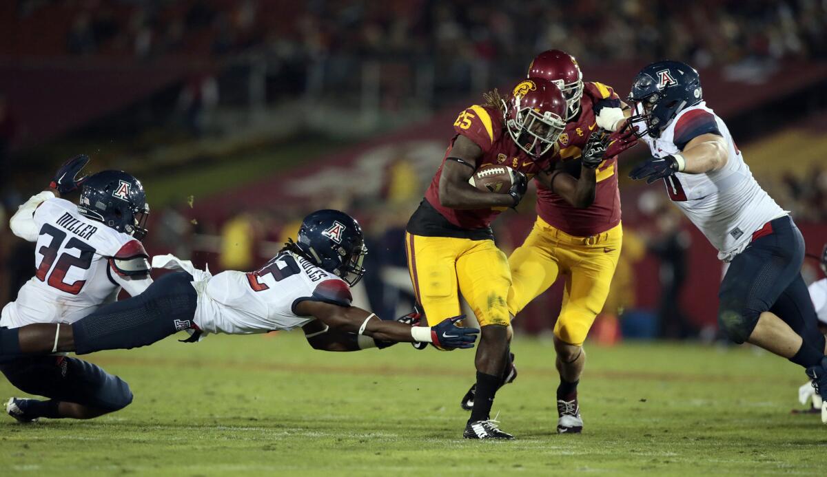 USC running back Ronald Jones II slips a tackle from Arizona safety Demitrius Flannigan-Fowles during the second quarter of a game at the Coliseum on Nov. 7.