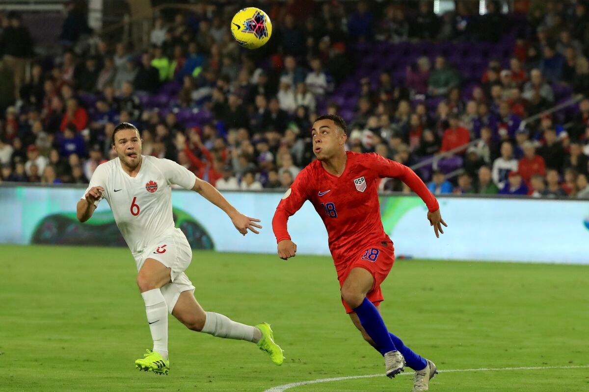 The United States' Sergino Dest, right, controls the ball against Canada on Friday night.