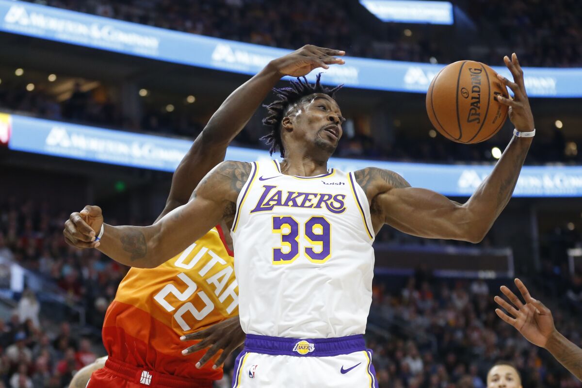 Lakers center Dwight Howard pulls down a rebound in front of Jazz forward Jeff Green (22) during the first half of a game Dec. 4 at Vivint Smart Home Arena.