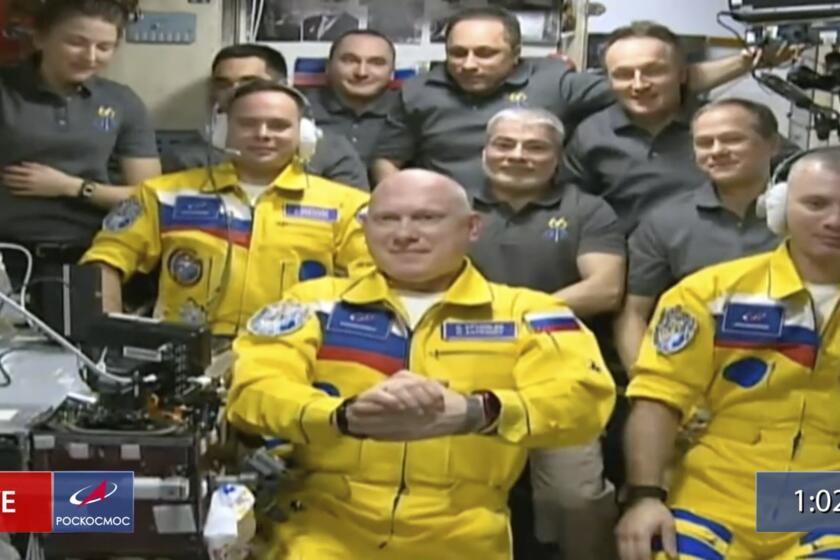 In this frame grab from video provided by Roscosmos, Russian cosmonauts Sergey Korsakov, Oleg Artemyev and Denis Matveyev are seen during a welcome ceremony after arriving at the International Space Station, Friday, March 18, 2022, the first new faces in space since the start of Russia’s war in Ukraine. The crew emerged from the Soyuz capsule wearing yellow flight suits with blue stripes, the colors of the Ukrainian flag. (Roscosmos via AP)