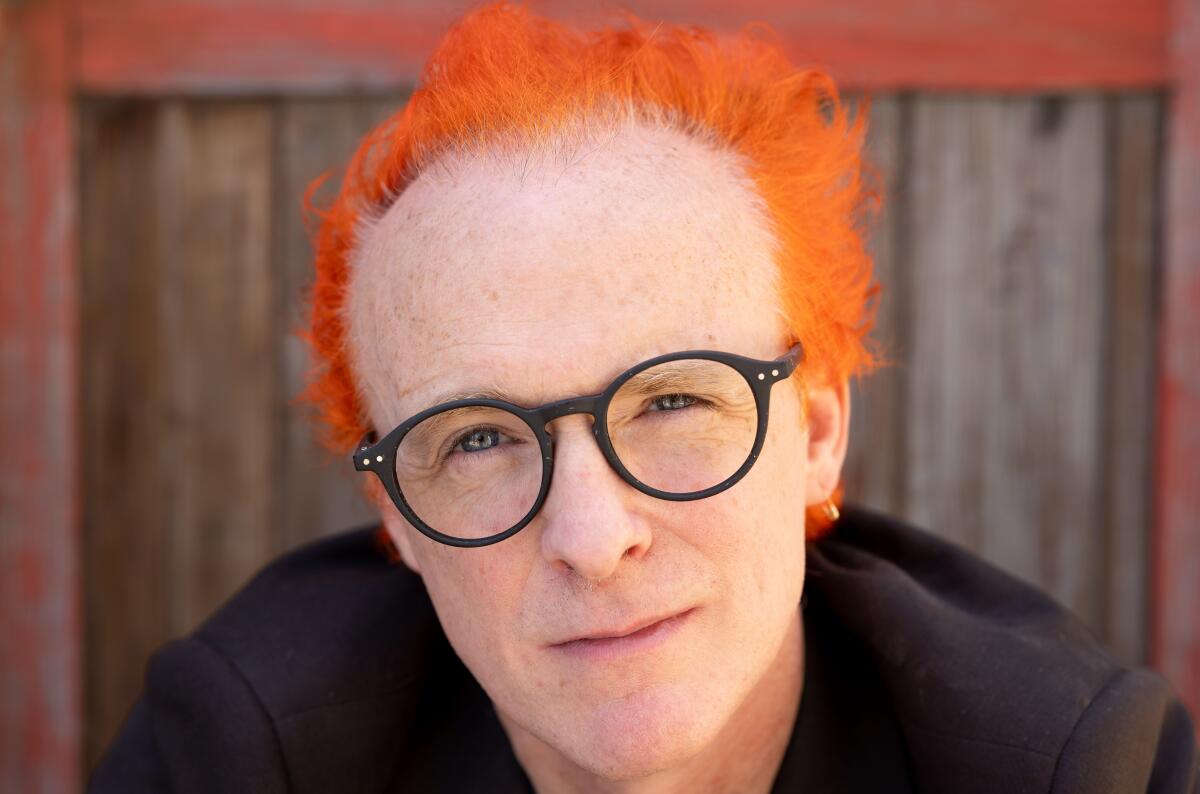 Man with bright orange hair and glasses