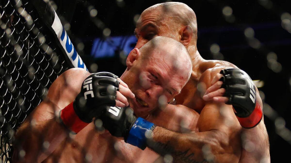 Ryan LaFlare, left, and Roan Carneiro grapple against the octagon during their welterweight bout at UFC 208.