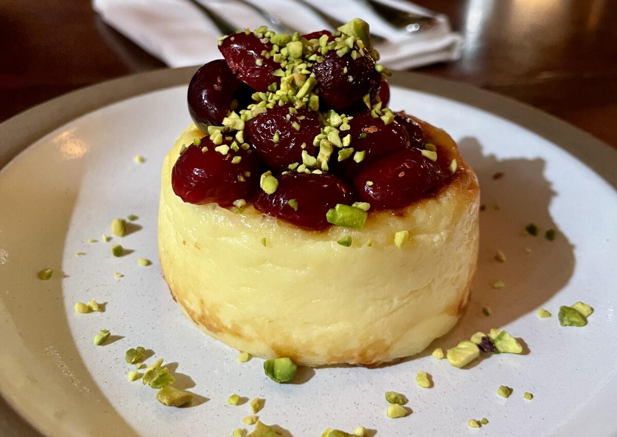 A small round 颁辞尘迟é cheesecake topped with cherries from Bicyclette restaurant in Los Angeles.