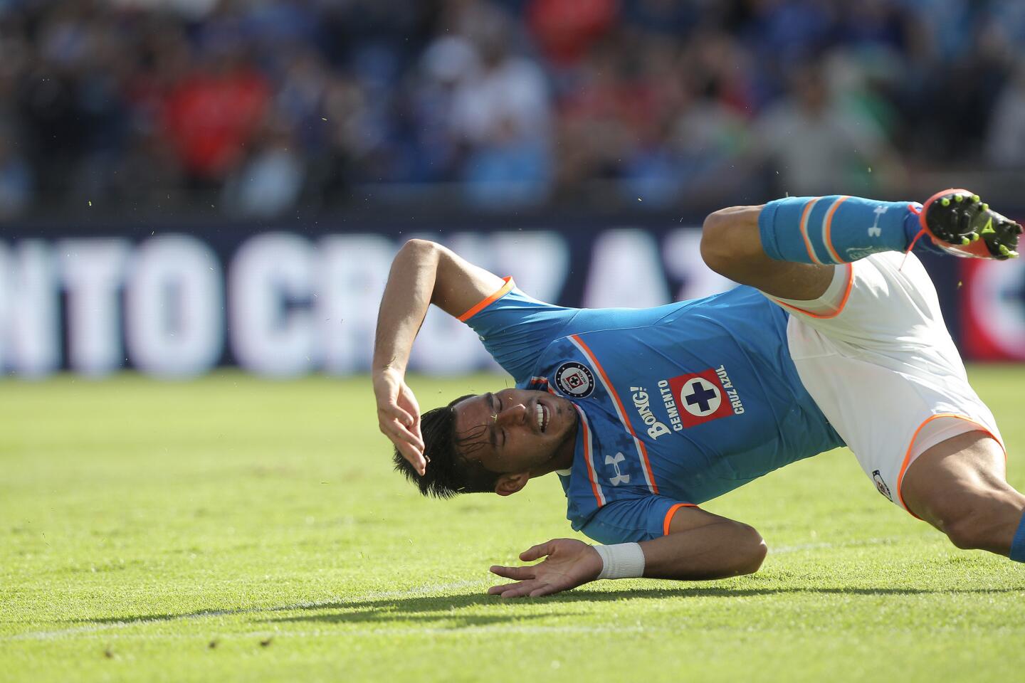 El jugador Jorge Benítez de Cruz Azul cae, en el juego correspondiente a la jornada 17 del Torneo mexicano de futbol, celebrado en el estadio Azul en Ciudad de México.