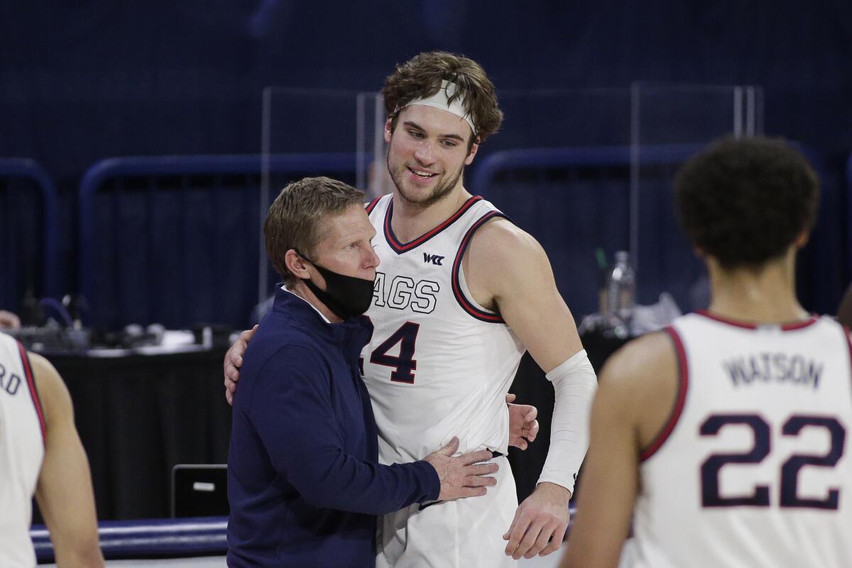 Gonzaga coach Mark Few, left, hugs forward Corey Kispert after Kispert, a senior playing his last home game, left the court near the end of the second half of the team's NCAA college basketball game against Loyola Marymount in Spokane, Wash., Saturday, Feb. 27, 2021. Gonzaga won 86-69. (AP Photo/Young Kwak)