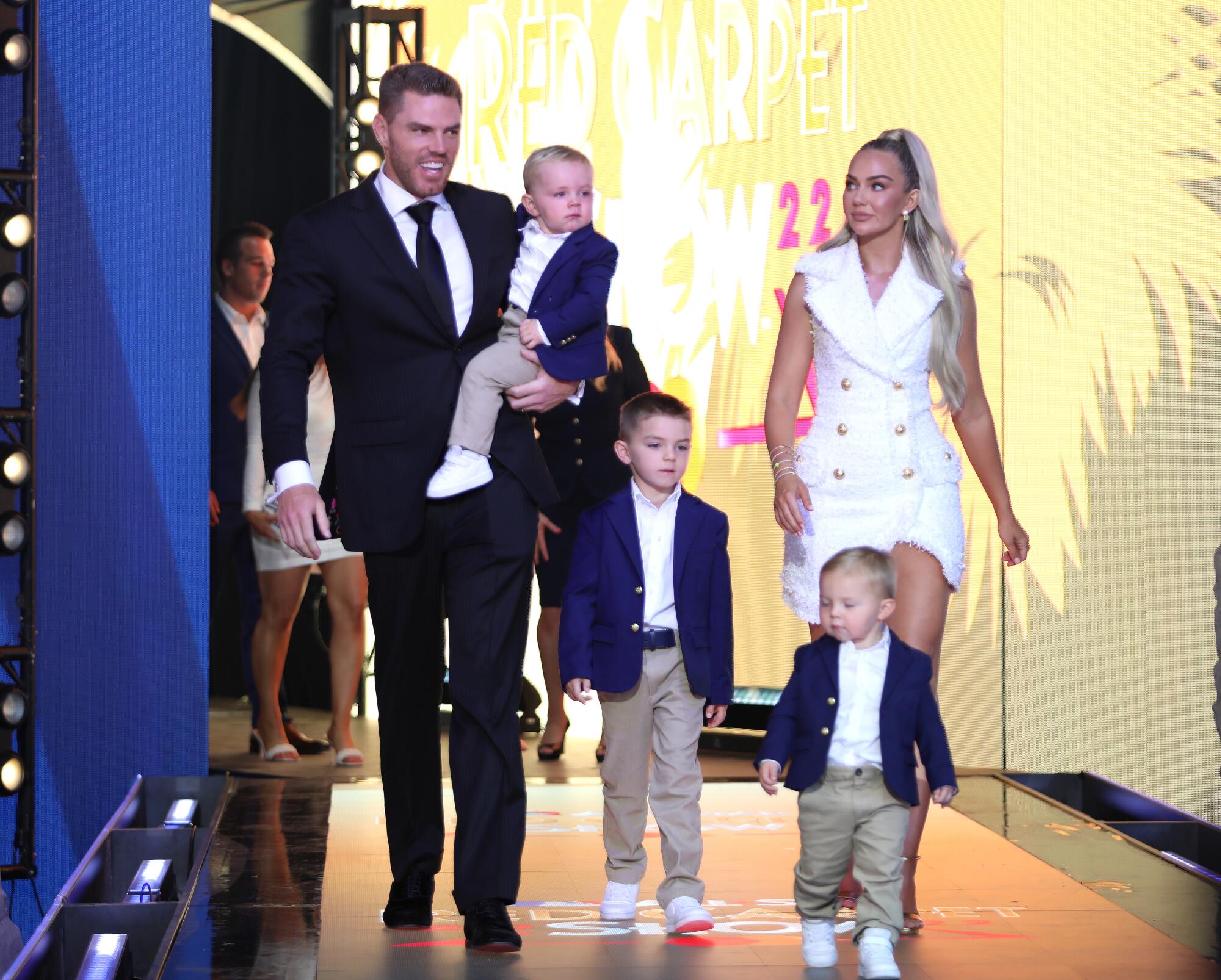 Freddie Freeman in a dark suit arrives with his family at the 2022 MLB All-Star Game Red Carpet Show.