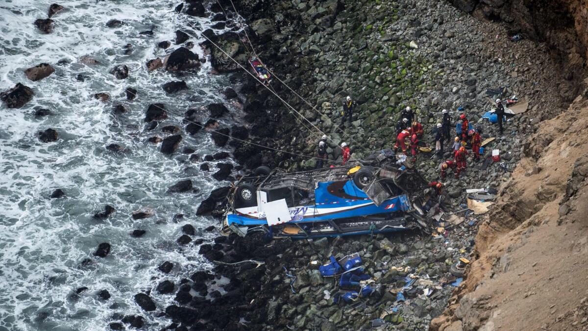 Rescuers, police and firefighters work at the scene after a bus collided with a truck and plunged over a cliff on a coastal highway near the Peruvian city of Pasamayo.