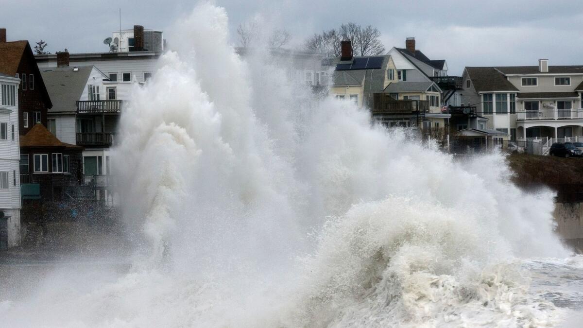 A large wave crashes into a seawall in Winthrop, Mass., on Saturday, a day after a nor'easter pounded the Atlantic coast.