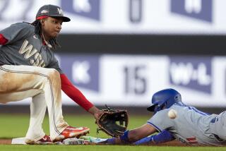 Washington Nationals shortstop CJ Abrams, left, waits for the throw as Los Angeles Dodgers' Miguel Rojas steals second base during the third inning of a baseball game at Nationals Park, Tuesday, April 23, 2024, in Washington. (AP Photo/Alex Brandon)