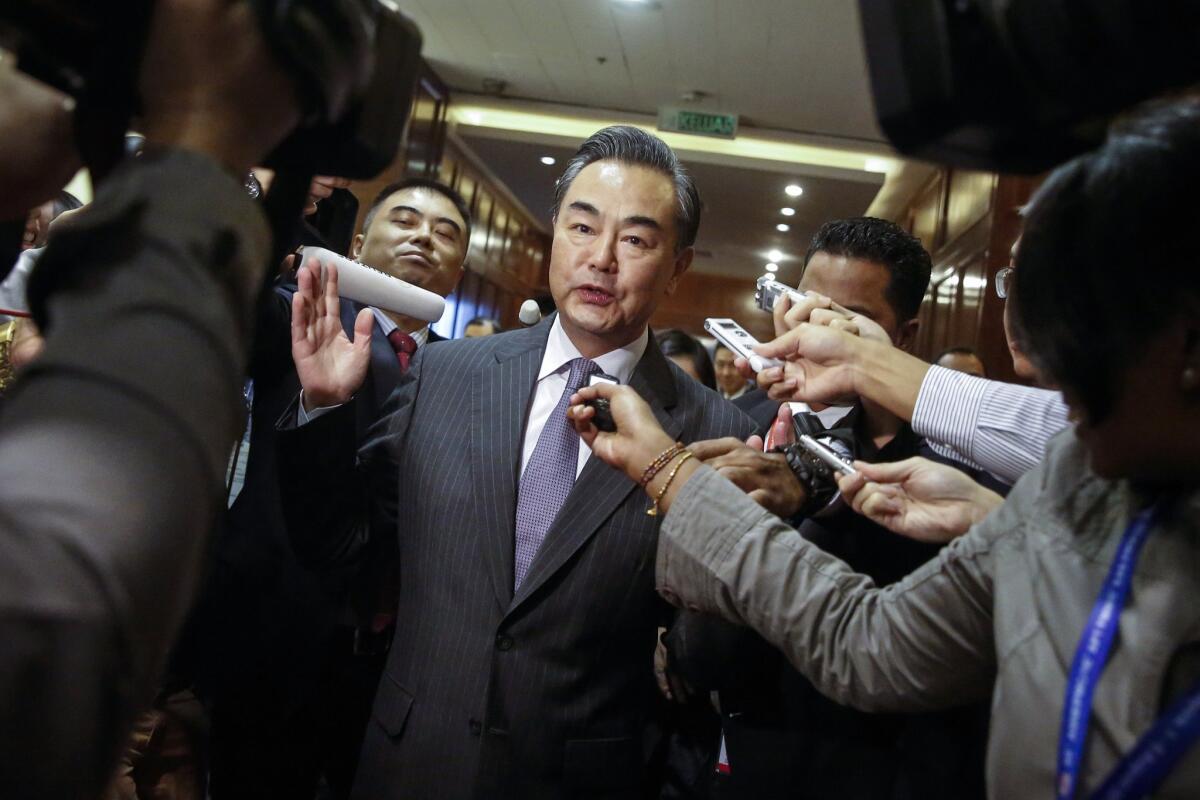 Chinese Foreign Minister Wang Yi is surrounded by journalists at the Assn. of Southeast Asian Nations foreign ministers meeting in Kuala Lumpur, Malaysia.