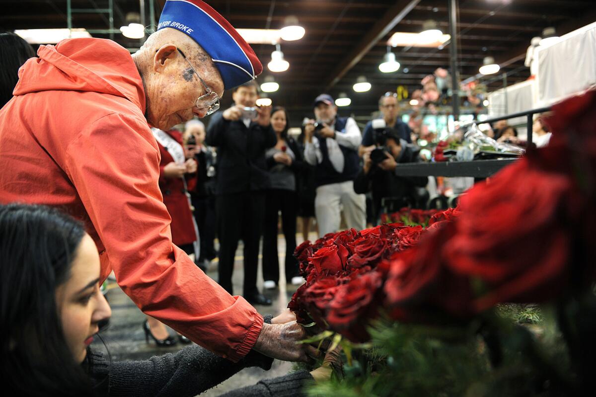 World War II veteran Robert Baba, 97, places a rose on a float sponsored by the city of Alhambra.
