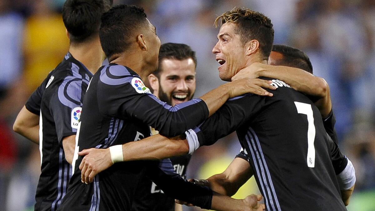 Cristiano Ronaldo (7) celebrates with teammates after a 2-0 victory over Malaga on Sunday.