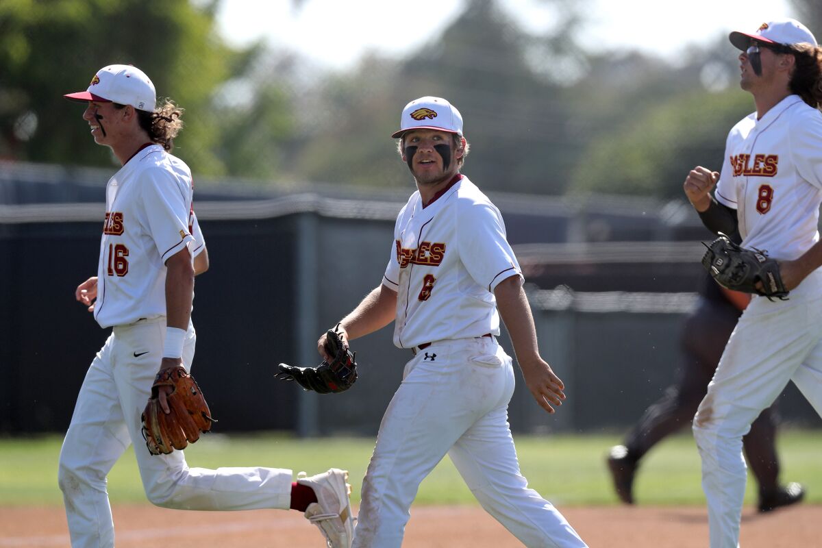 Estancia pitcher Trevor Scott, center, looks on after the Eagles close out the top of the third inning against Santa Ynez.