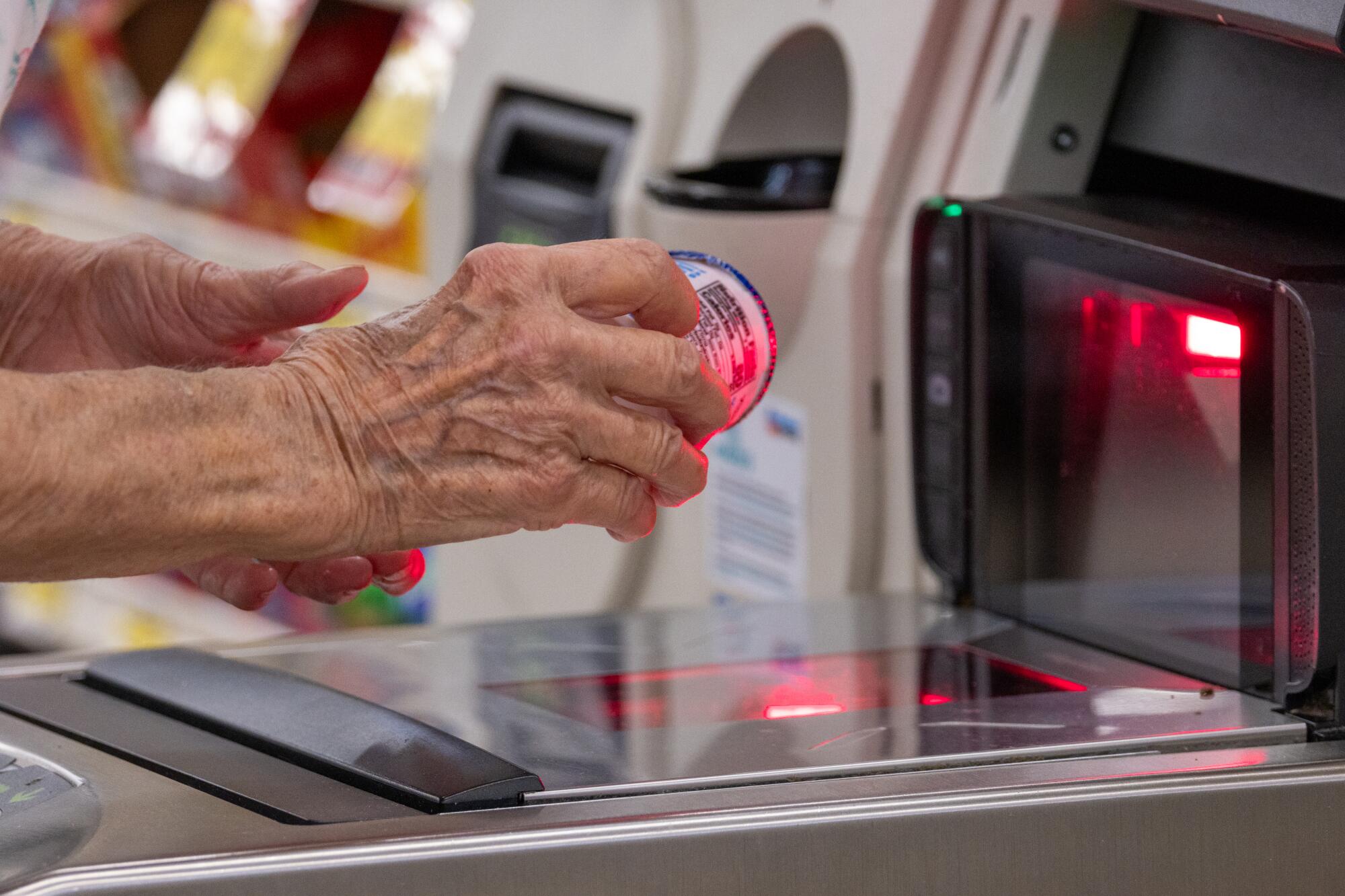 A customer uses self-checkout at a grocery store.