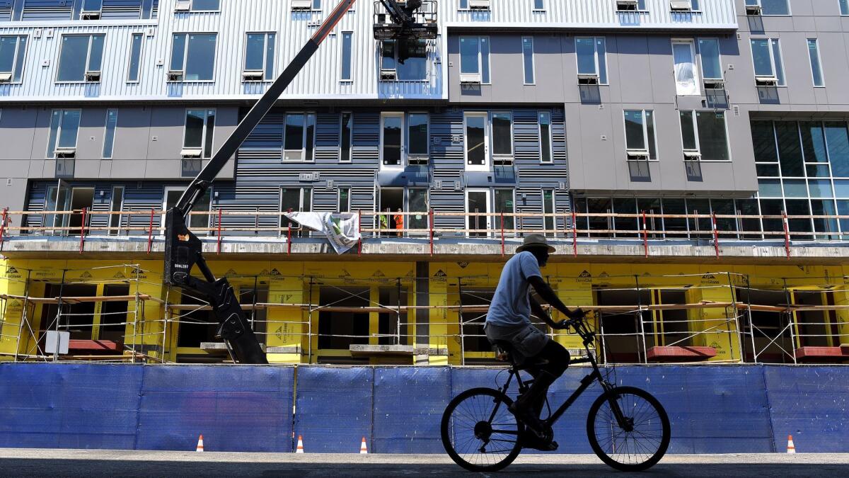 A bicyclist passes by construction in downtown Los Angeles on Aug. 3.