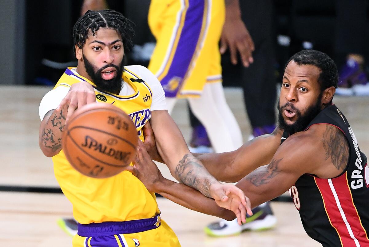 Lakers' Anthony Davis gets a pass off in front of Miami Heat's Andre Iguodala.