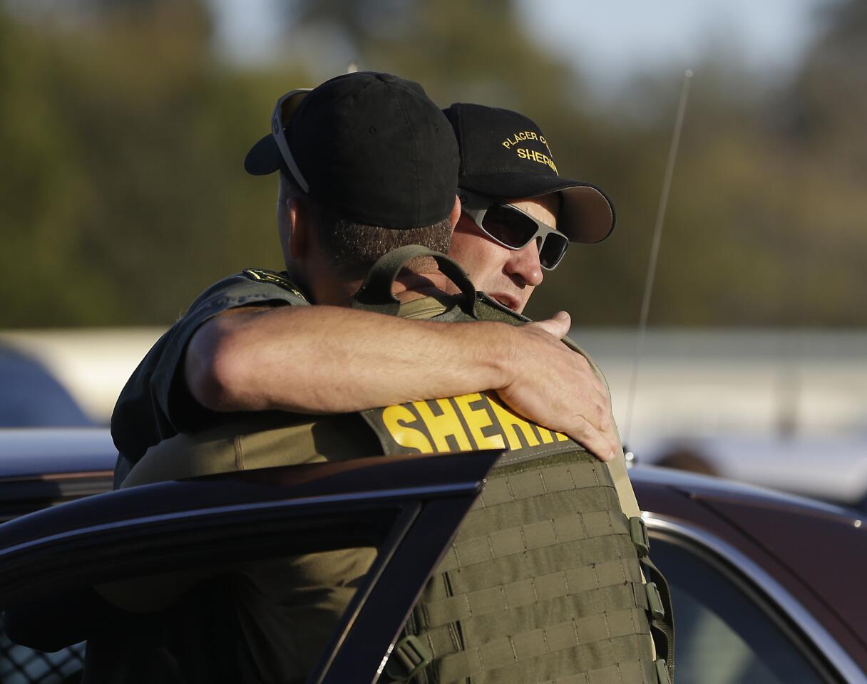 A pair of Placer County sheriff's deputies embrace after a suspect was arrested who allegedly shot and killed two deputes, wounded a third and a bystander during a series of shootings that spanned across two California counties.