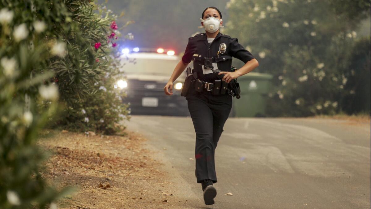 A police officer runs to evacuate residents in the La Tuna fire in Sunland, Calif. on Sept. 30, 2017.